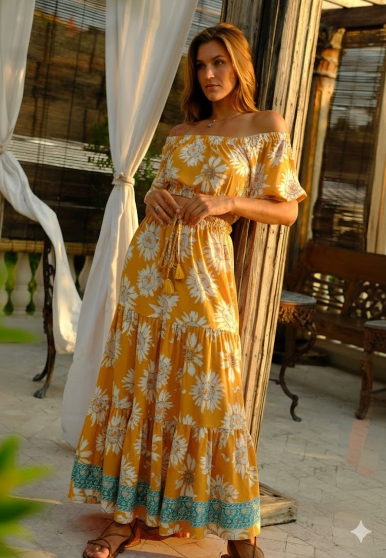 Woman wearing a yellow floral dress standing in an outdoor setting.