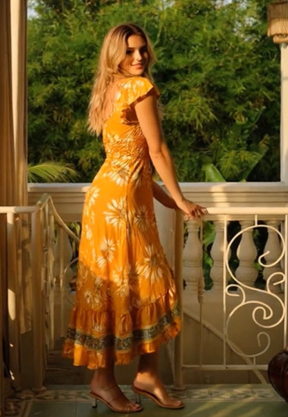 woman in Sunflower Silk Midi Dress with Open Back  and tassels from coral secret