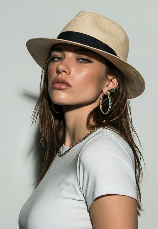 Woman wearing a beige hat with a black band against a gray background