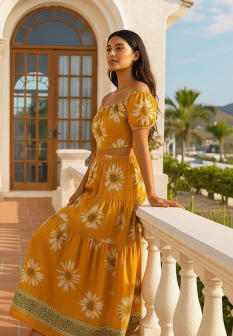 Woman in a yellow floral dress standing on a balcony with a scenic background