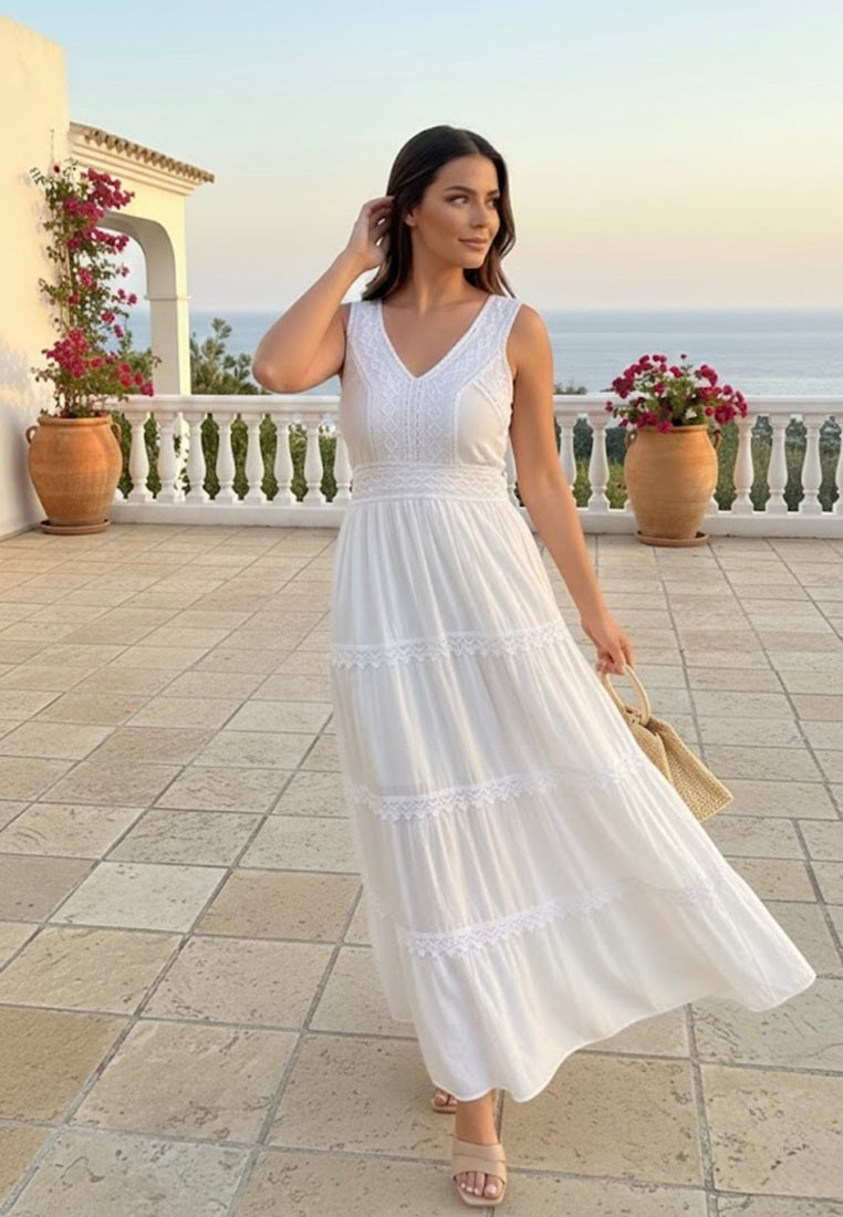 Woman in a white dress standing on a balcony with ocean view